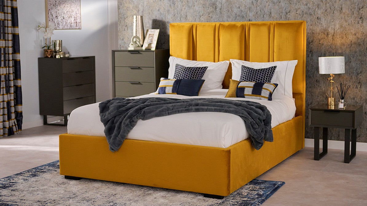 Mustard yellow velvet bed frame in bedroom dressed with pillows and a throw.