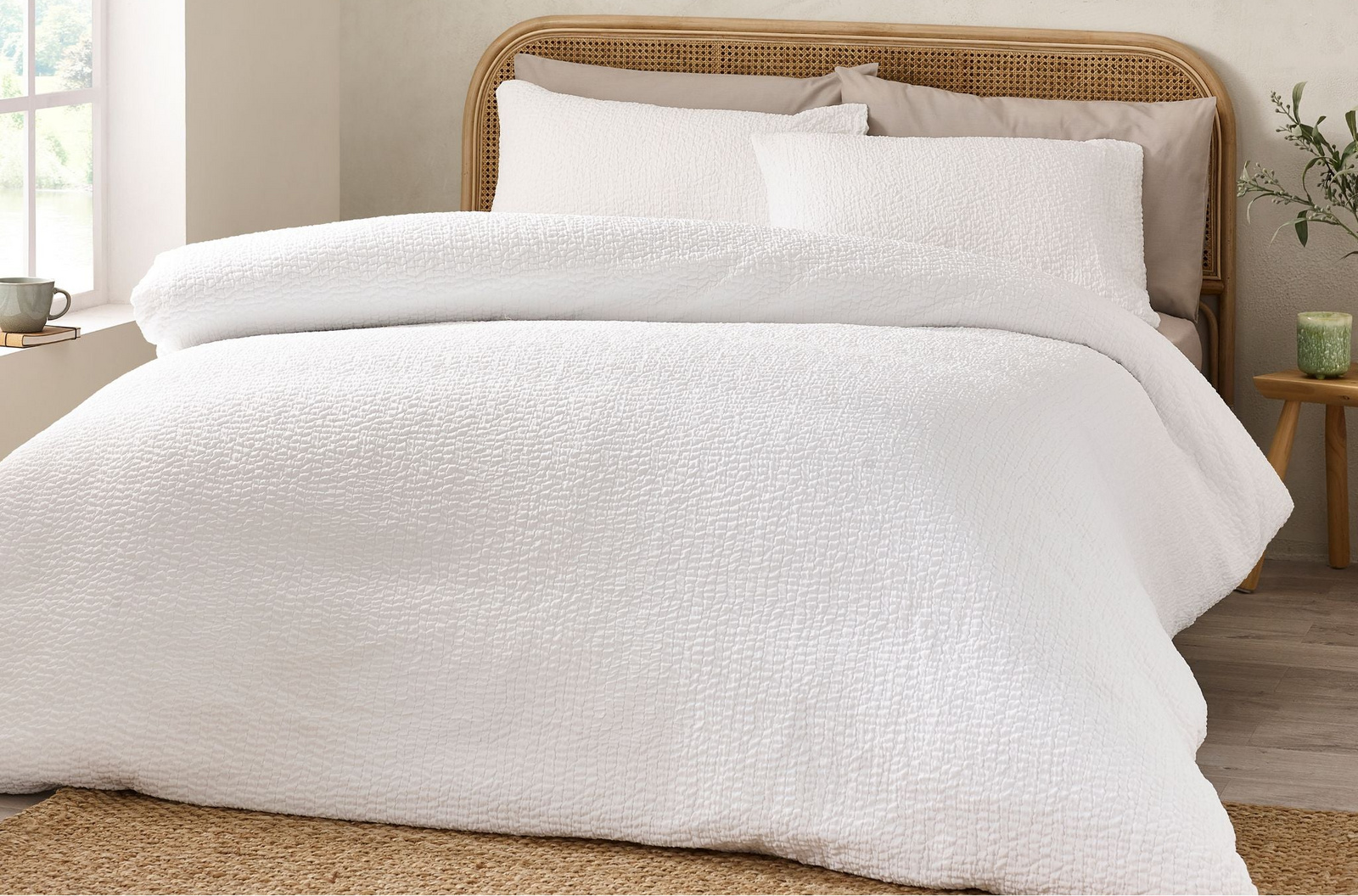 White bedding set on a bed with a wooden headboard in a bedroom setting.