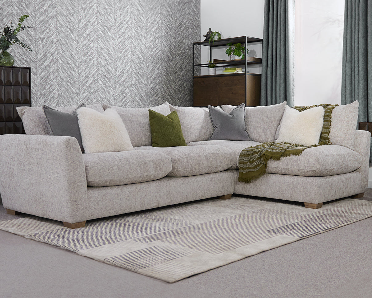 Grey sectional sofa with colourful cushions in a living room setting.