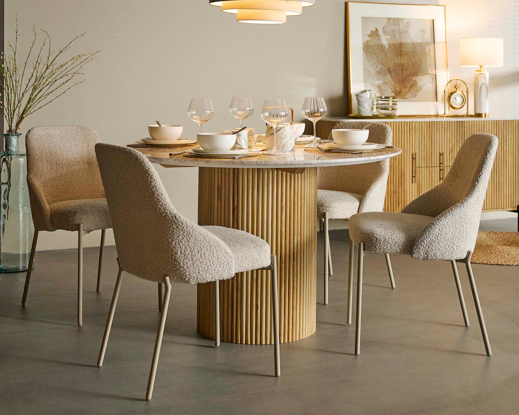 Dining room with a round table and chairs, featuring a modern lamp and decor.