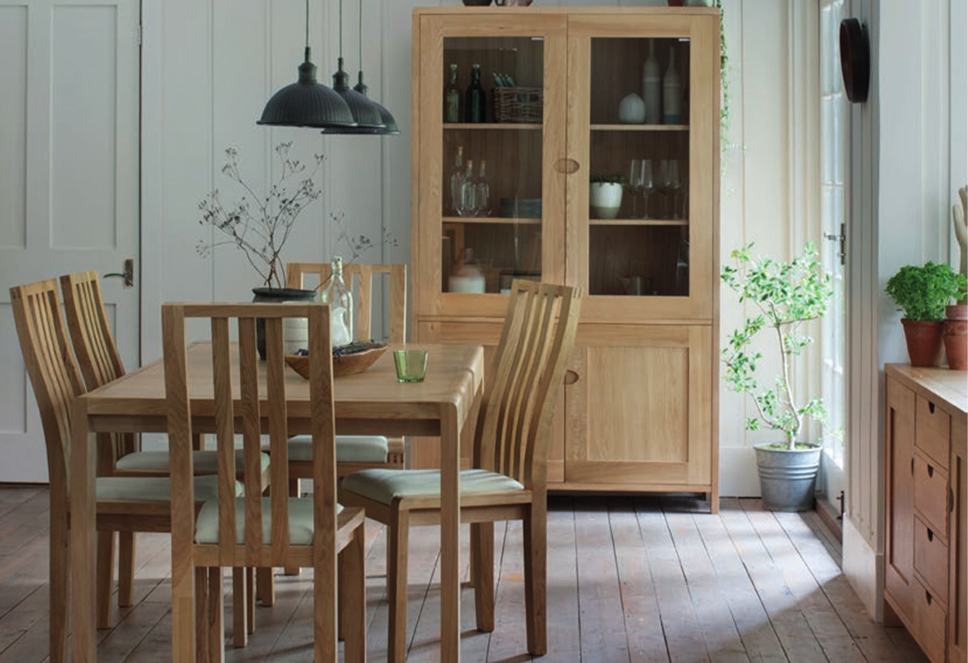 Wooden dining set with a cabinet in a bright room