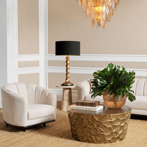 Modern living room with beige armchair, coffee table, and decorative elements.