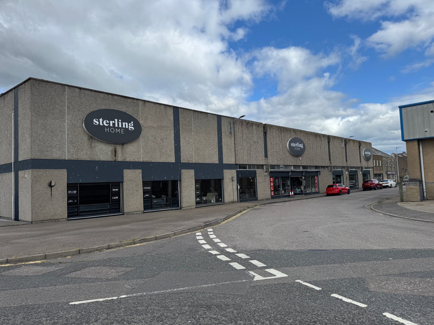 Commercial building with 'sterling HOME' branding on a cloudy day