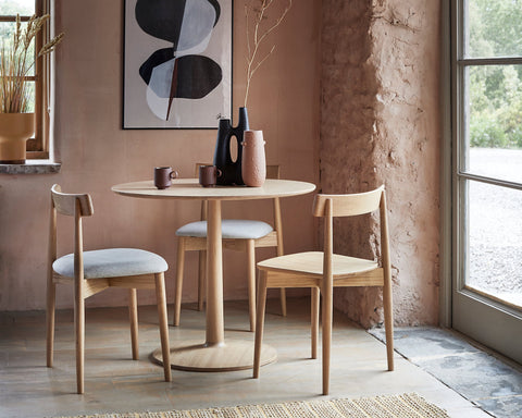 Dining area with round table and chairs in a room with natural light