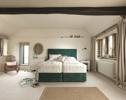 Bedroom with Harrison Spinks green divan set and white bedding, featuring a chair and window.