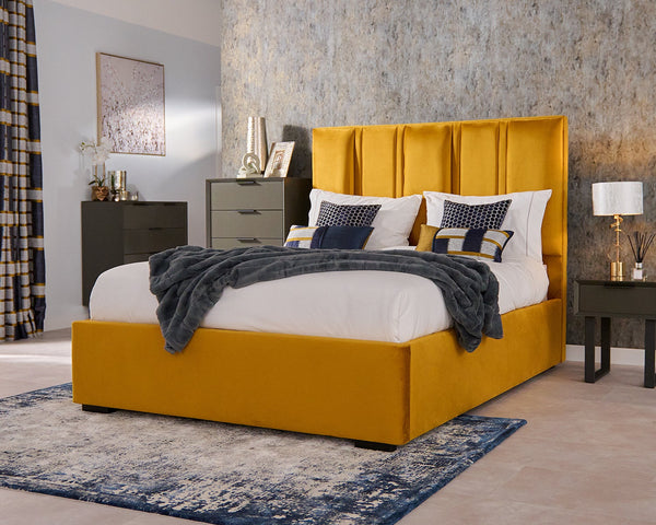 Yellow bed with white bedding and grey blanket in a bedroom setting.