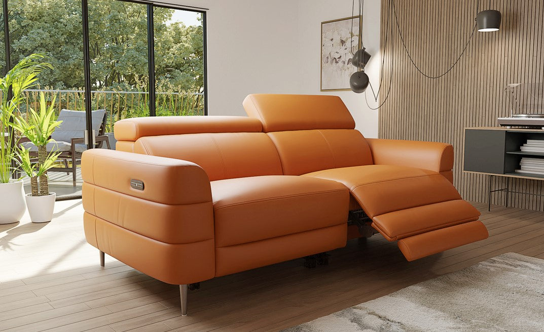 Orange sectional sofa in a modern living room with plants and a view of greenery outside.