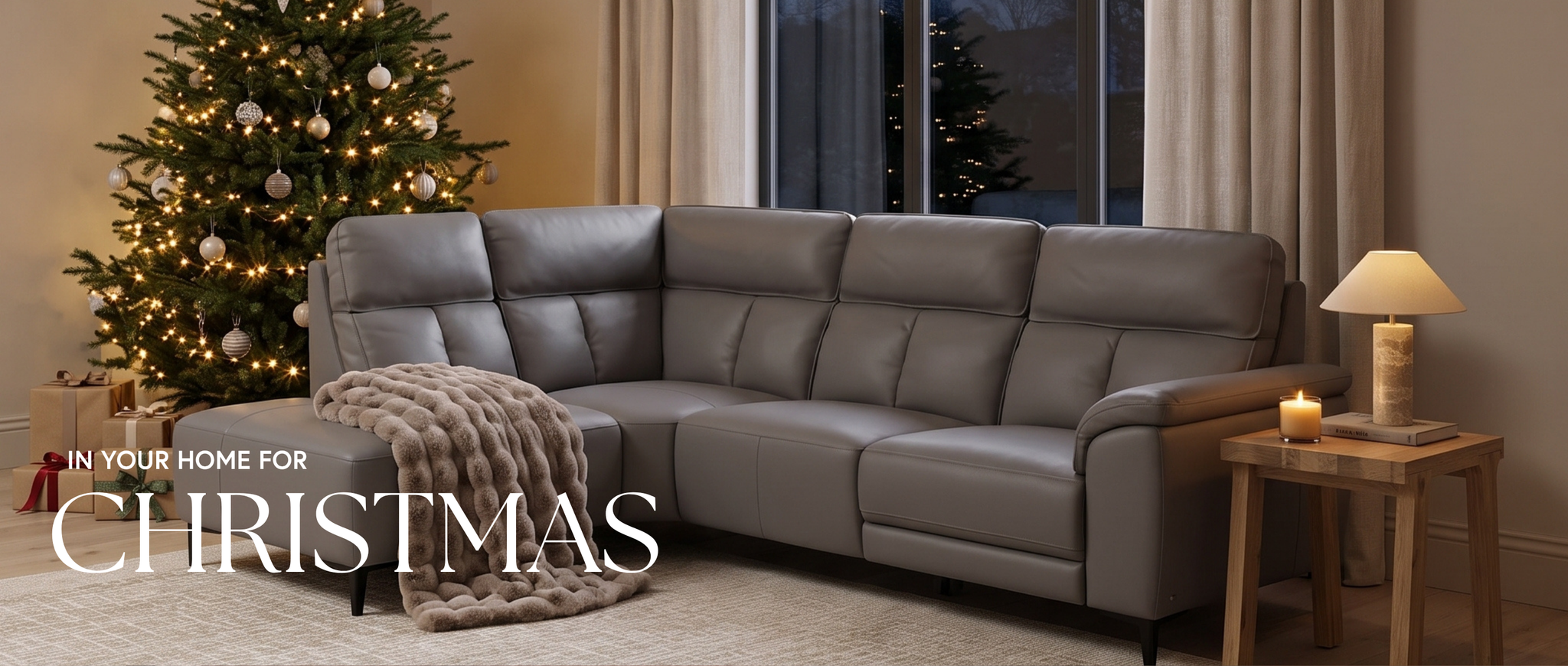 An image of a grey leather corner sofa in a modern living with a christmas tree in the background, and text on the image saying 'IN YOUR HOME FOR CHRISTMAS'