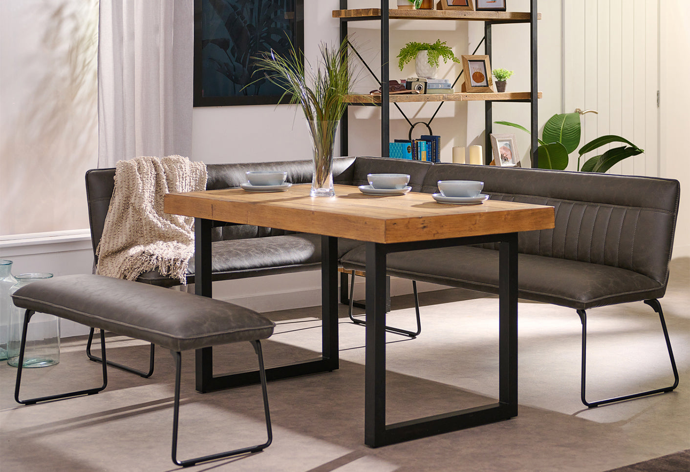 Dining room with wooden table, grey chairs, and a bench.