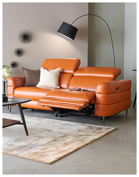 Orange leather sofa in a modern living room with a lamp and rug.