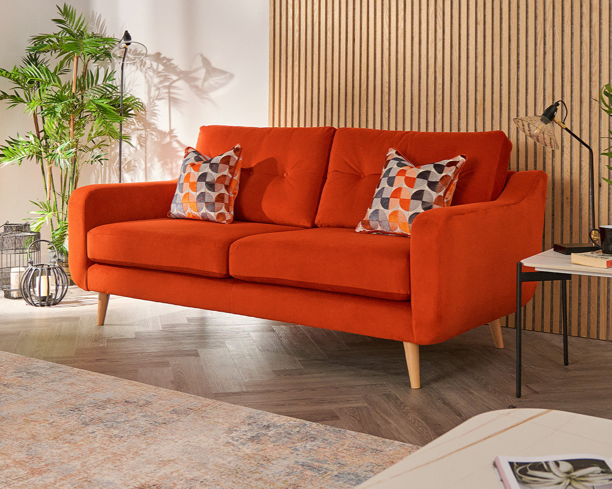 Orange sofa with patterned cushions in a living room setting