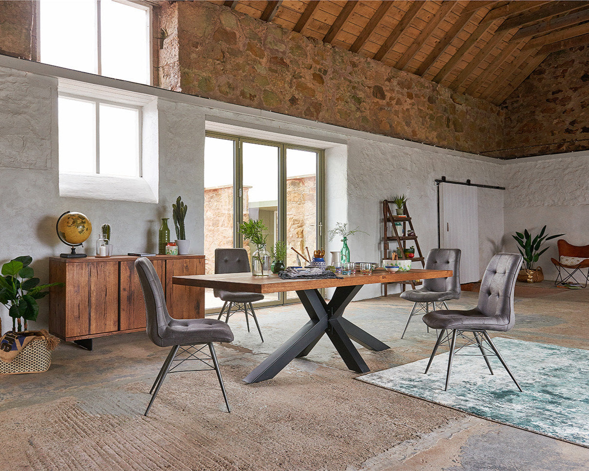 Modern dining area with wooden table and chairs in a rustic setting