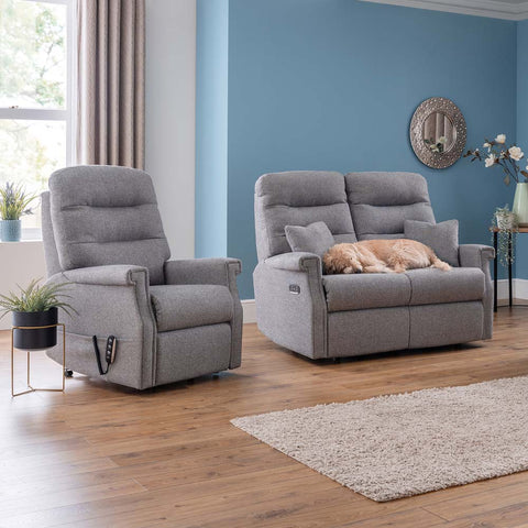 Grey recliner chairs in a living room with a dog on one of them.