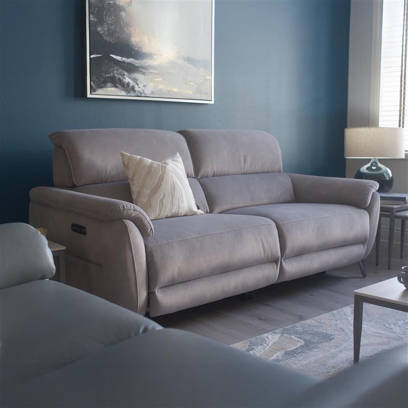 Grey sofa in a living room with a blue wall and framed artwork.