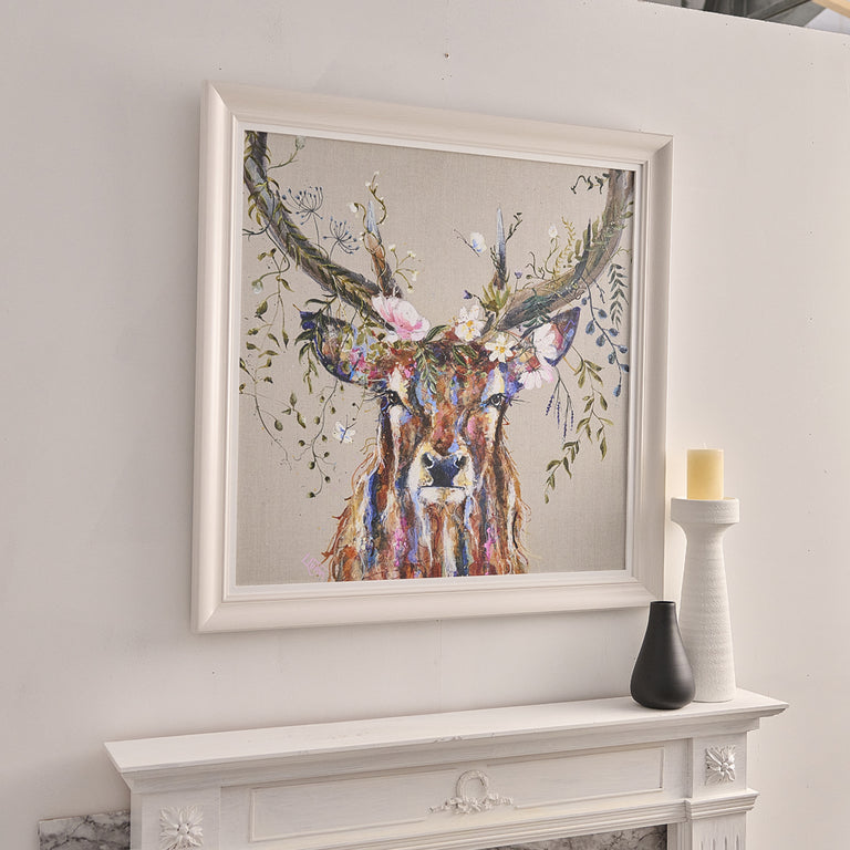 Framed artwork of a deer with floral antlers above a fireplace.