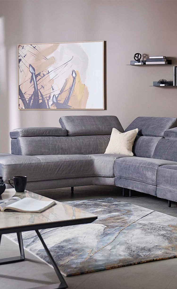 Grey sectional sofa in a living room setting with decor elements.
