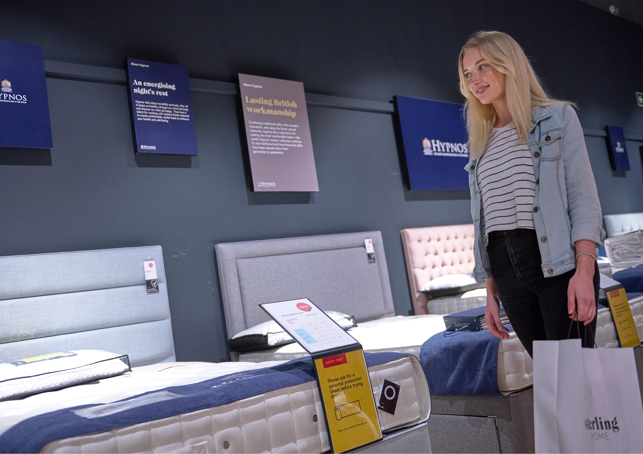 Woman looking at different types of beds and mattresses.