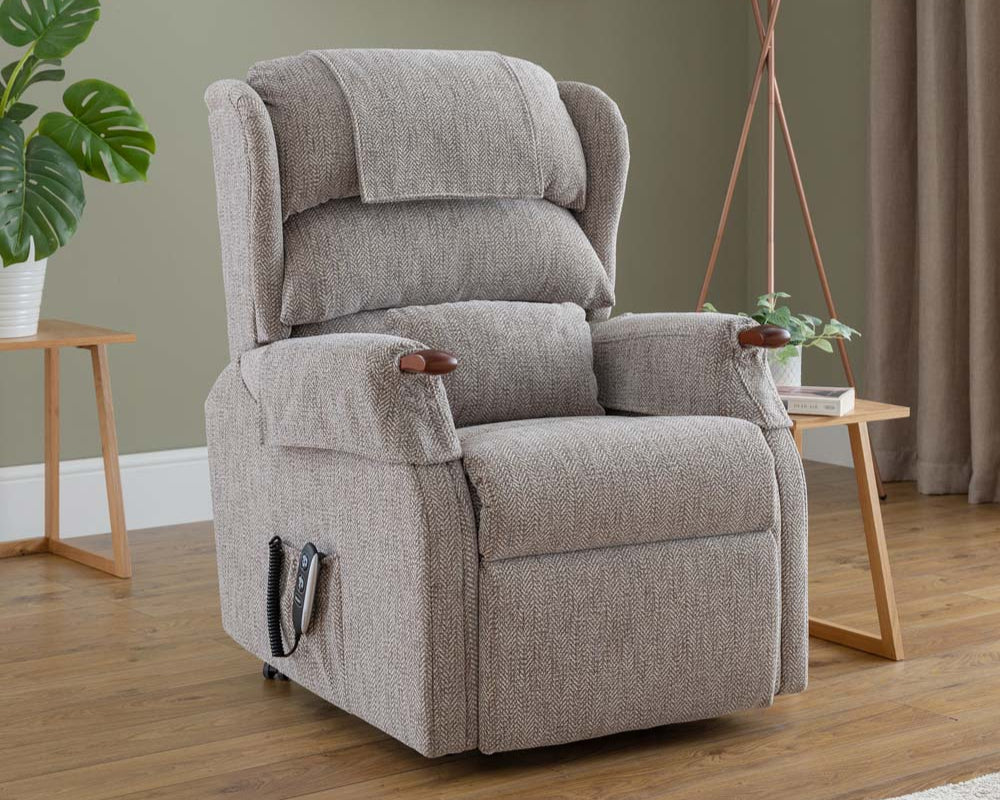Grey recliner chair in a living room setting with a lamp and plant.