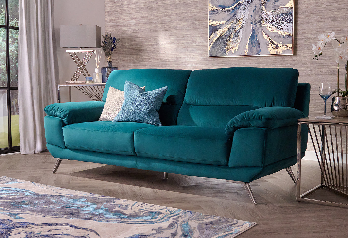 Teal sofa in a living room setting with decor elements.