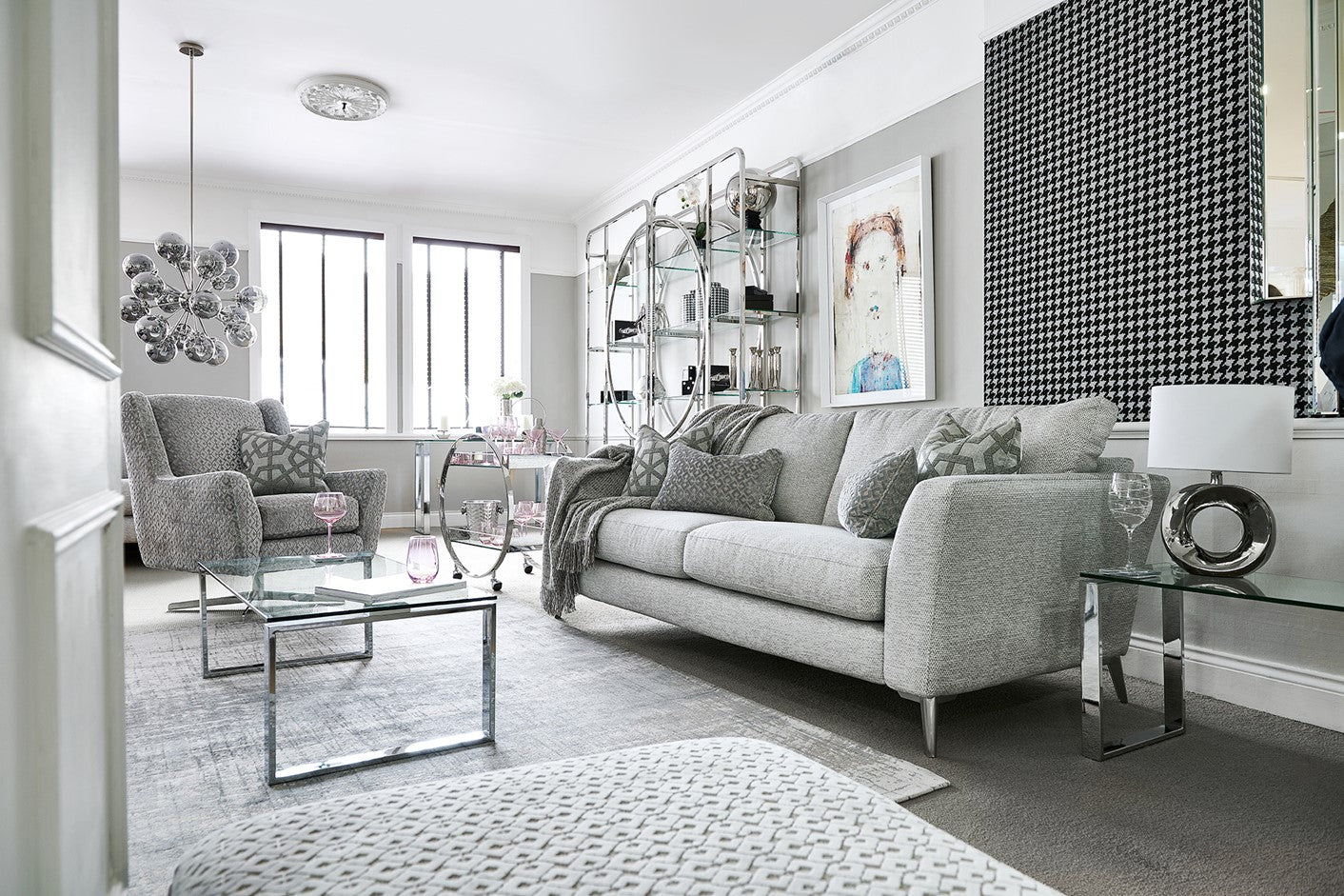 Modern living room with grey 3 seater sofa, glass coffee table, and decorative elements.