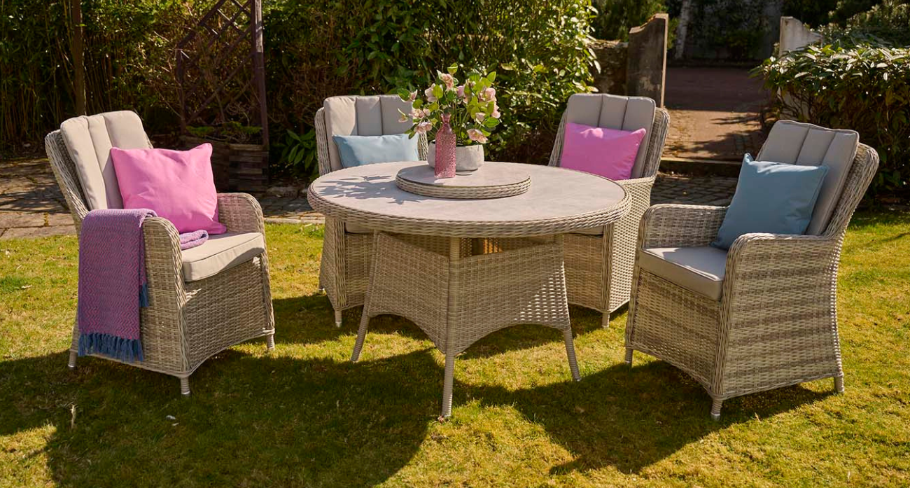 Garden furniture set with chairs and a table on a grassy area