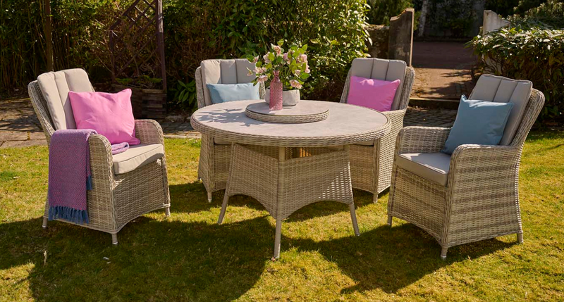 Garden furniture set with chairs and a table on a grassy area