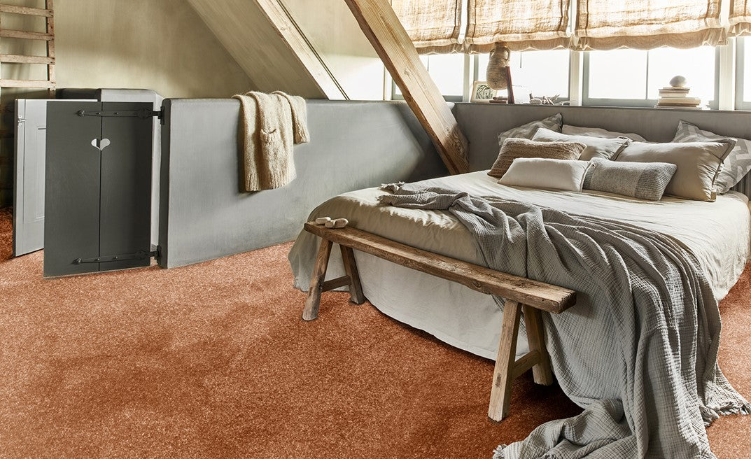 Cosy bedroom with a bed and soft orange carpet.