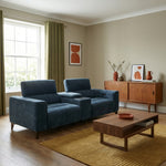 Modern living room with blue sofa, wooden coffee table, and sideboard.