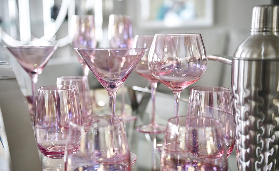 Pink cocktail glasses and a silver cocktail shaker 