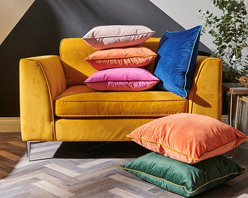 Yellow sofa with colorful pillows on a wooden floor