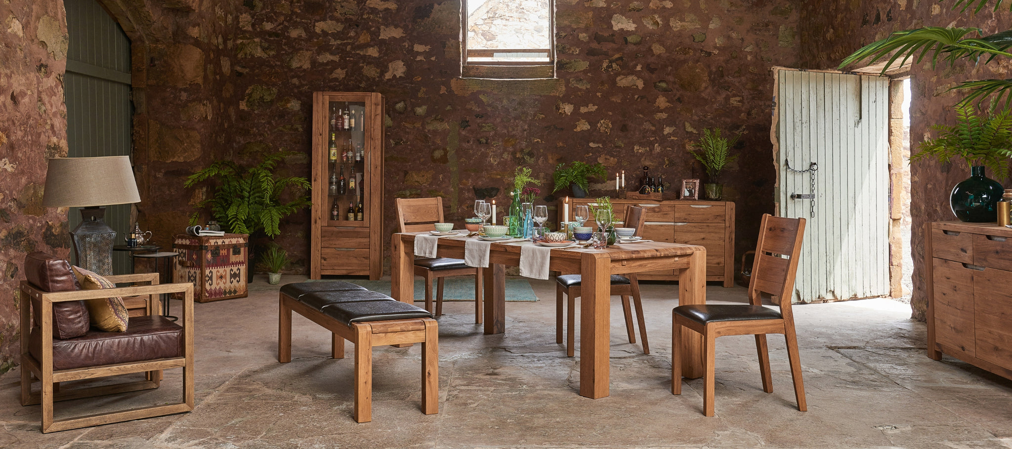 Solid oak Dining table and sideboards featured in a rustic setting with lots of greenery and home accessories 