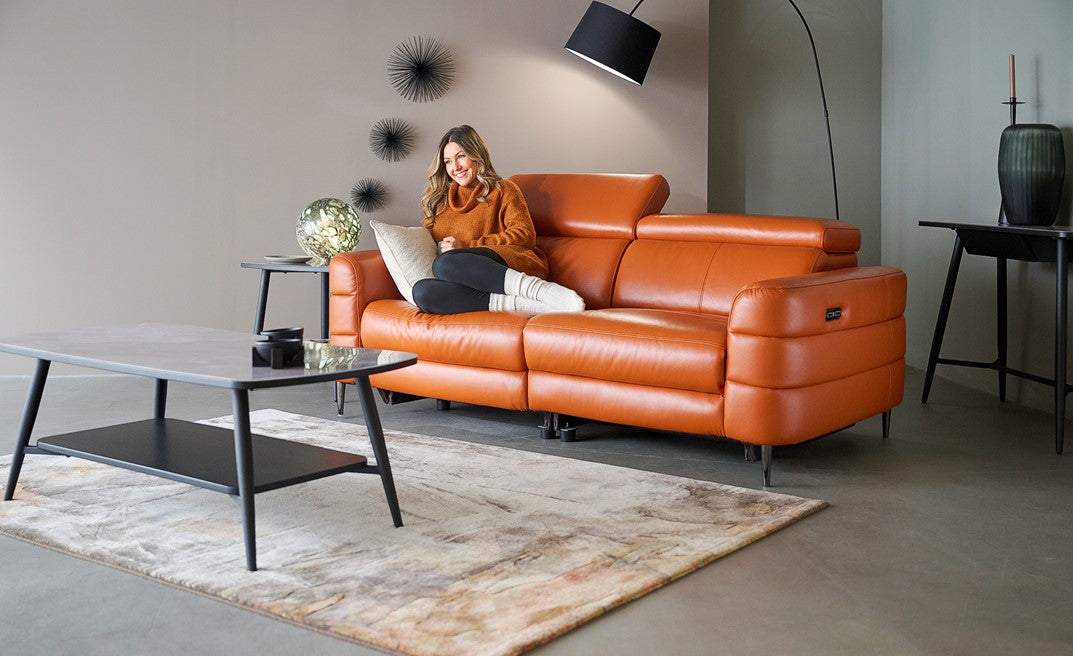 3 seater orange leather sofa with a marble effect rug and coffee table 