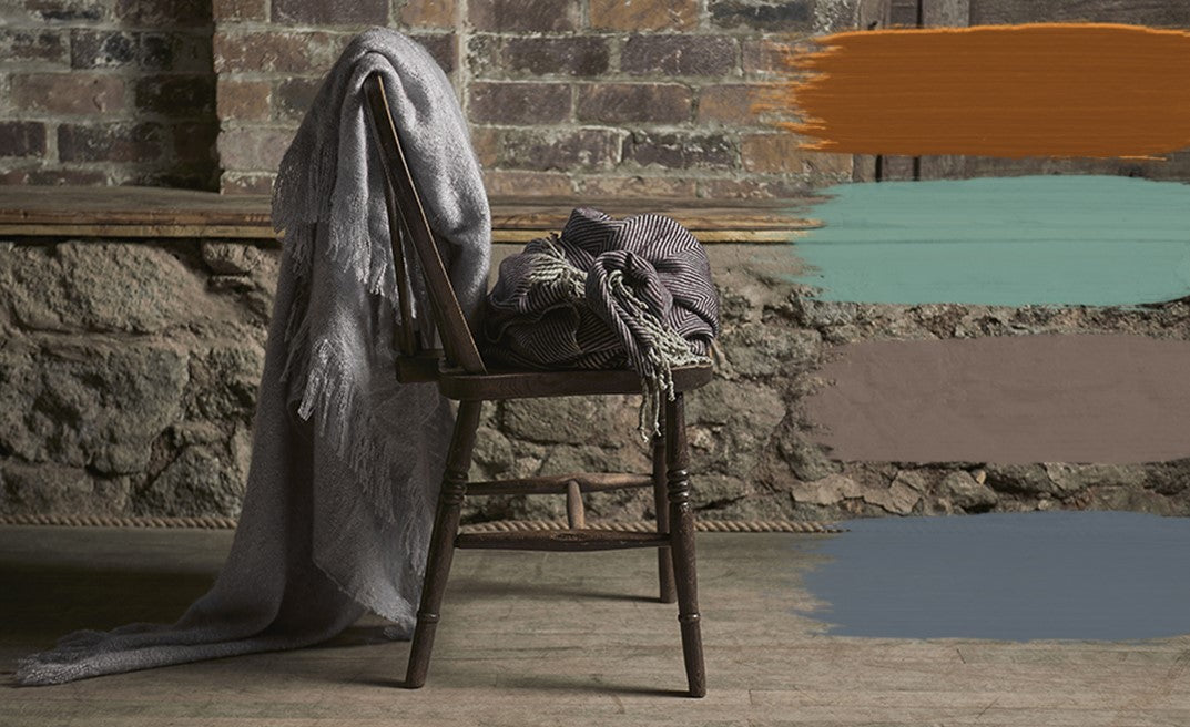 Chair with a blanket against a brick wall, with colour swatches.