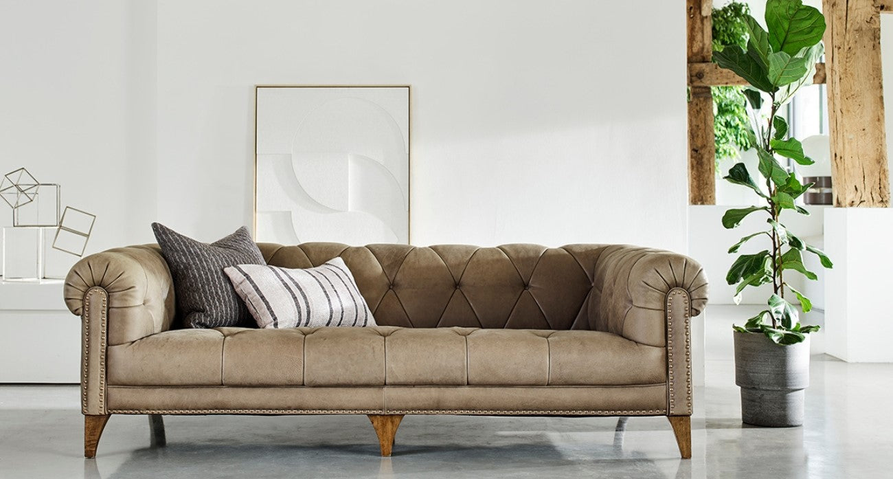 Brown large leather sofa with cushions in a modern living room setting