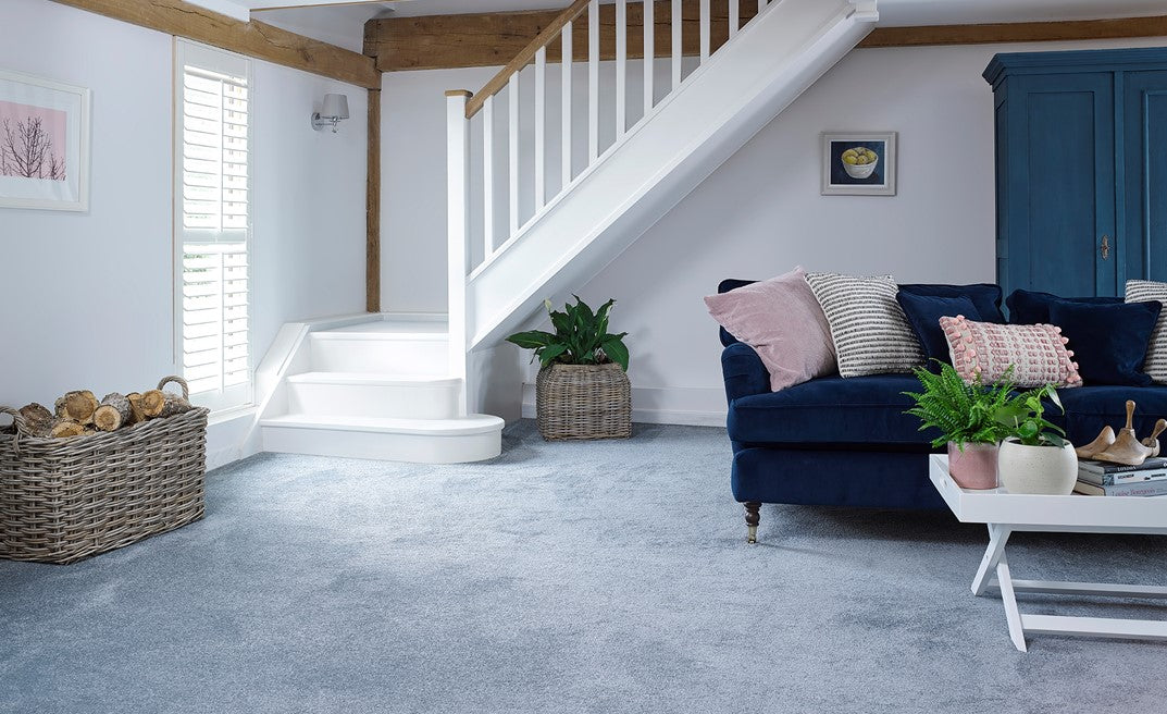Living room with a blue sofa and a sofa grey carpet. 