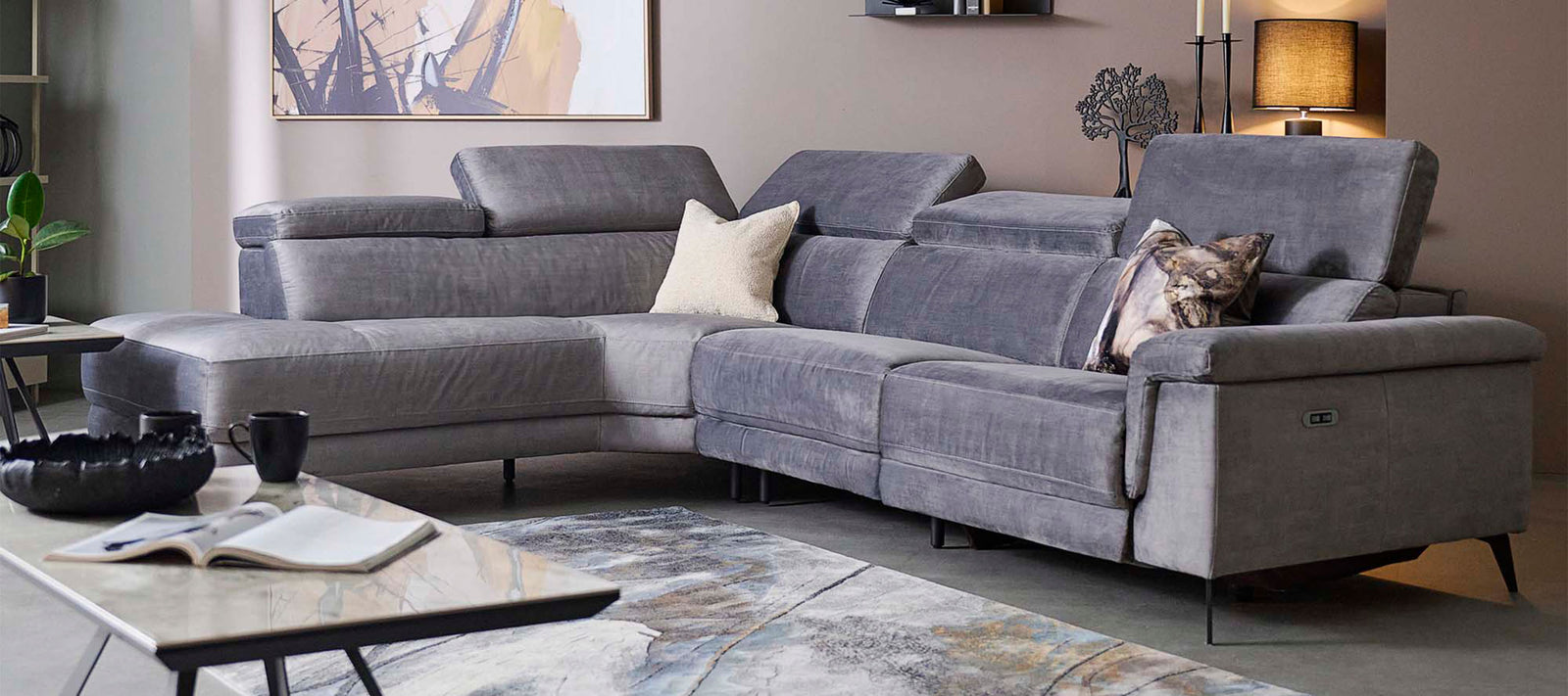 Grey sectional sofa in a living room setting with decor elements.
