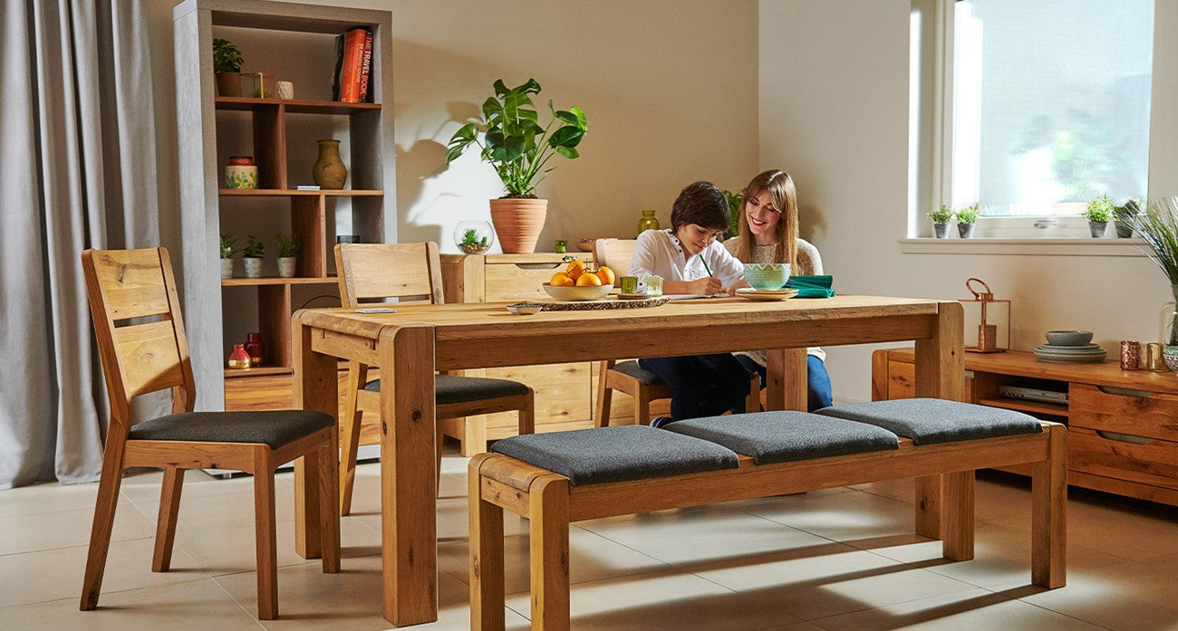 Dining room with wooden table, chairs, and a cushioned bench. 