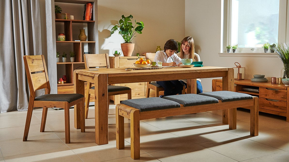 Wooden dining table and chairs with a cushioned bench. 