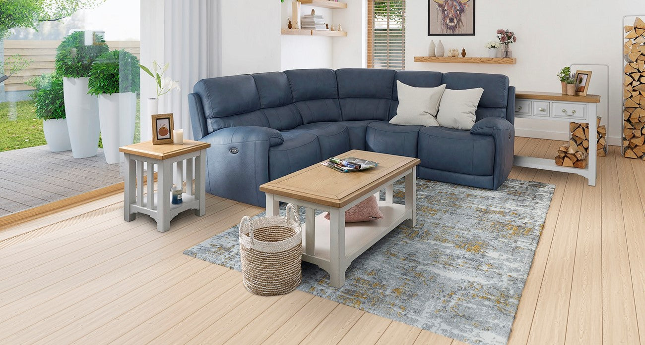 Blue leather recliner corner sofa in a living room with wooden coffee table and decorative items.