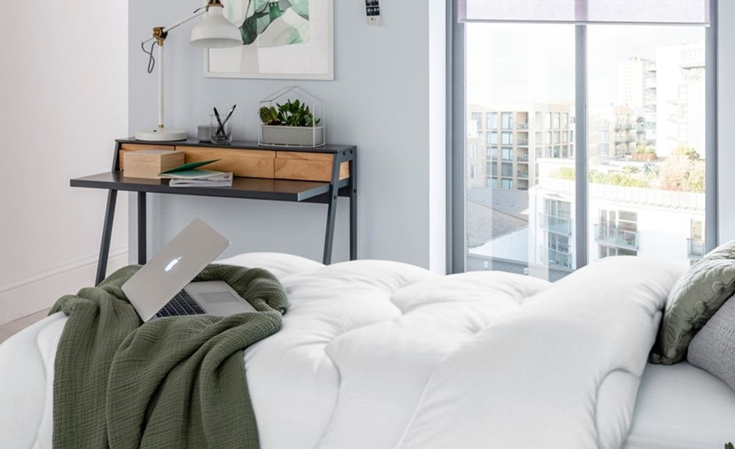 White fluffy duvet laid on a bed in a modern bedroom