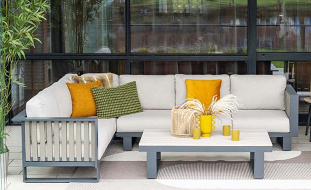Garden furniture patio set with a sectional sofa, coffee table, and decorative items.