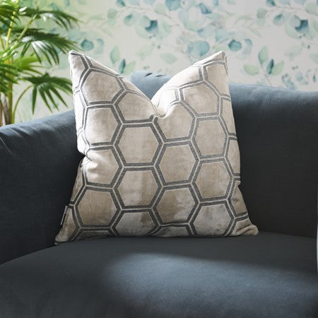Decorative pillow with geometric pattern on a grey sofa.